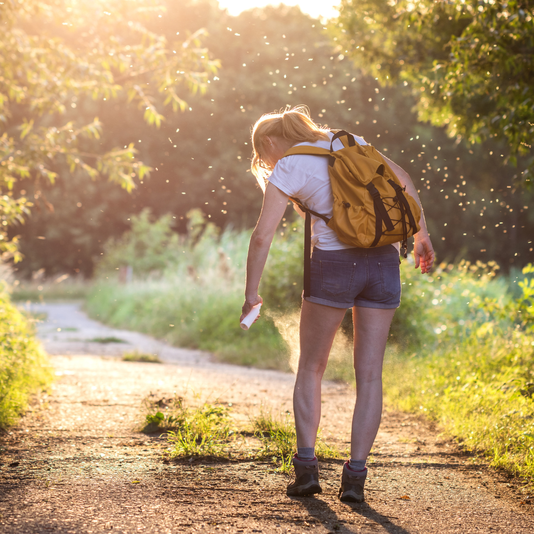 woman spraying herself with mosquito repellent - featured image for blog about mosquito repellent for large areas