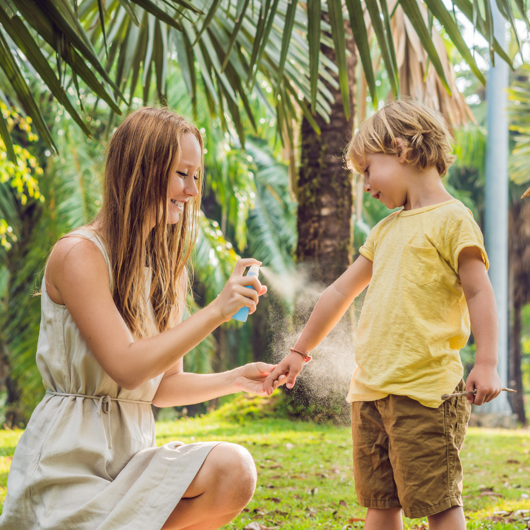 mother spraying child with mosquito repellent image for blog on natural mosquito repellent