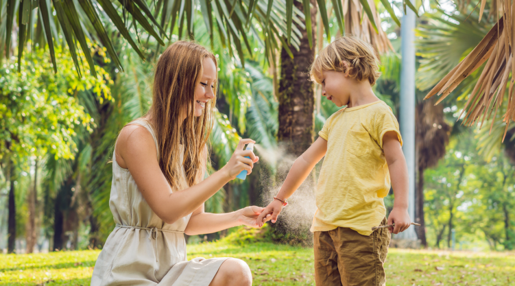 mother spraying child with mosquito repellent image for blog on natural mosquito repellent