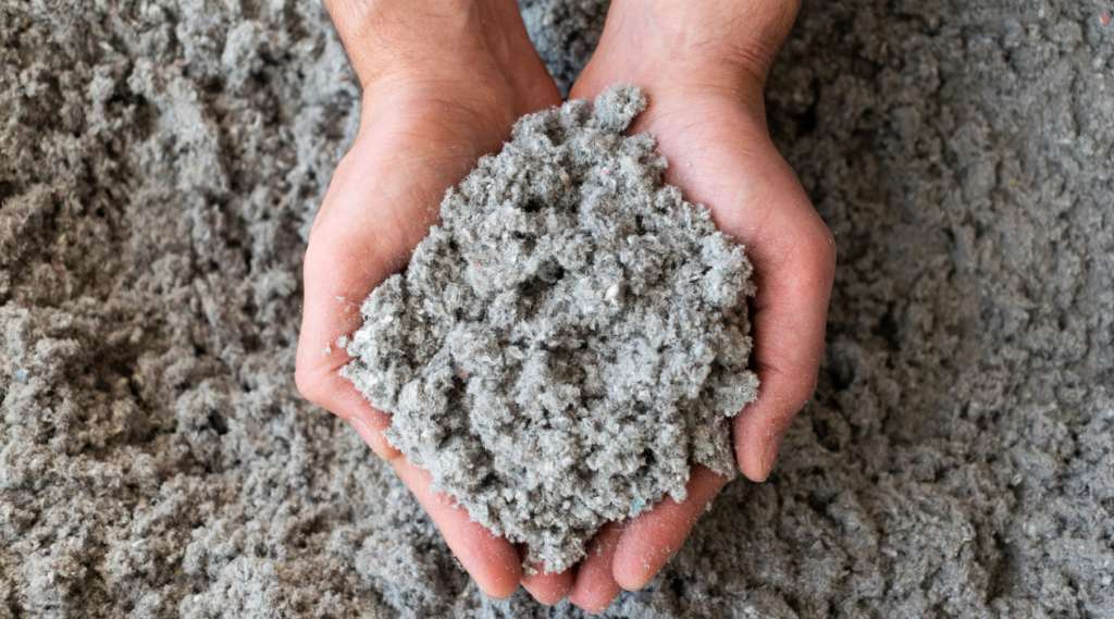 hands holding cellulose insulation