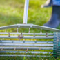 A lawn worker pushes an aeration tool across a yard.